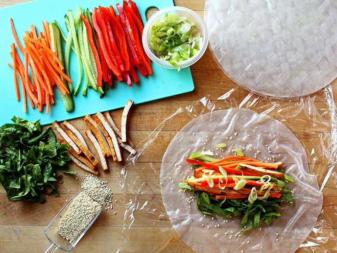 Ingredients prepared for making Vegan Rice Paper Rolls: Fresh vegetables and sliced Sriracha and Soy Sauce Tofu.
